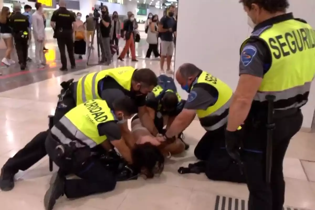 Imatge dels vigilants de seguretat mentre reduïen una dona a l'estació de Sants