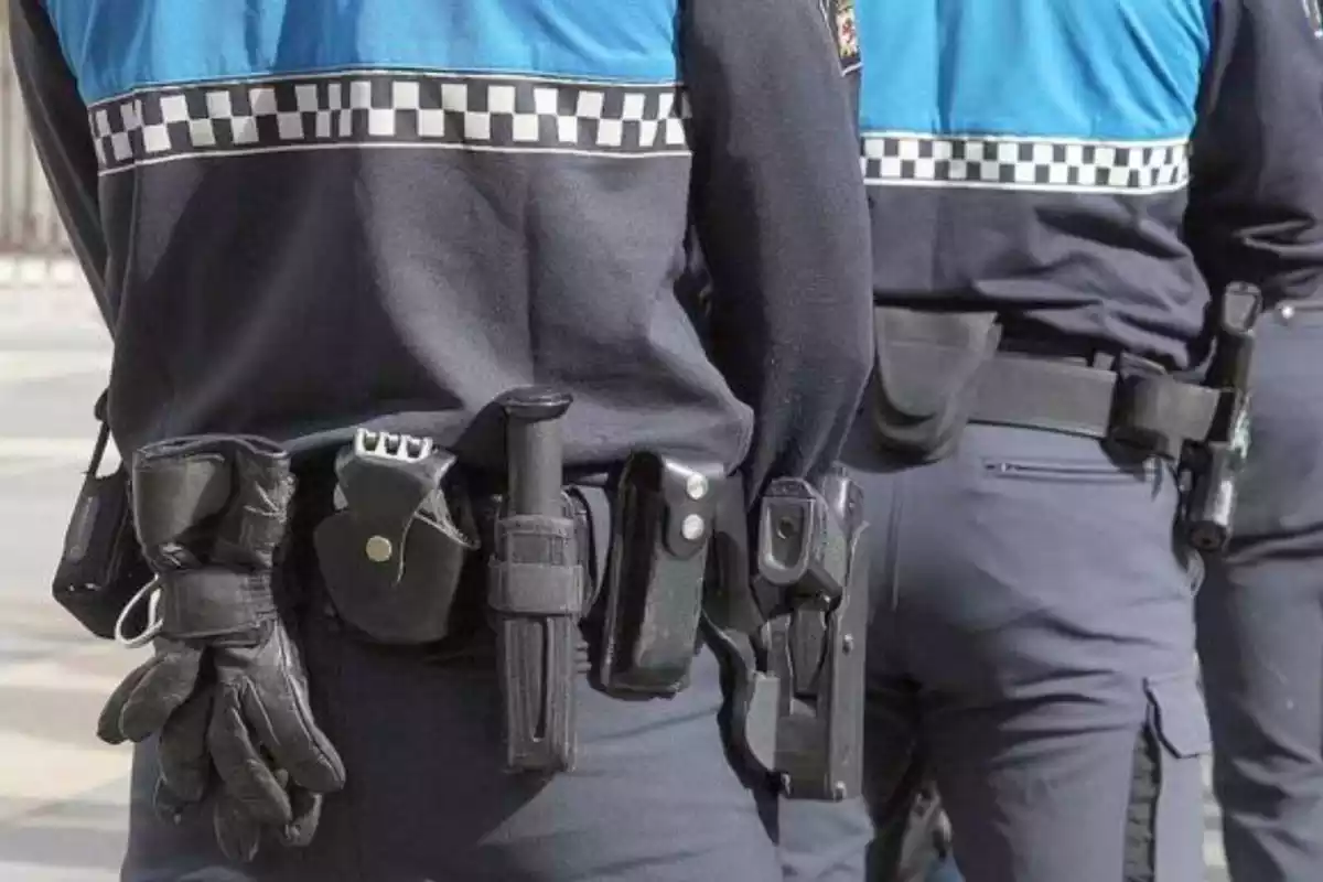 Pla detall de dos agents de policia local amb armes al cinturó