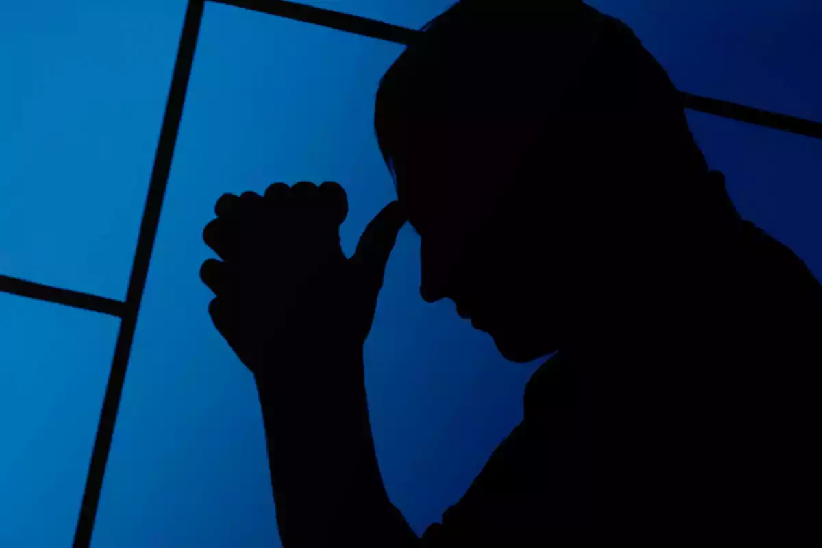 Imatge de la silueta negra d'una persona amb un fons blau