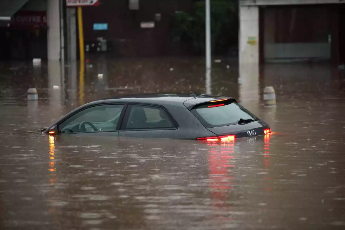Imatge d'un cotxe en mig d'una inundació