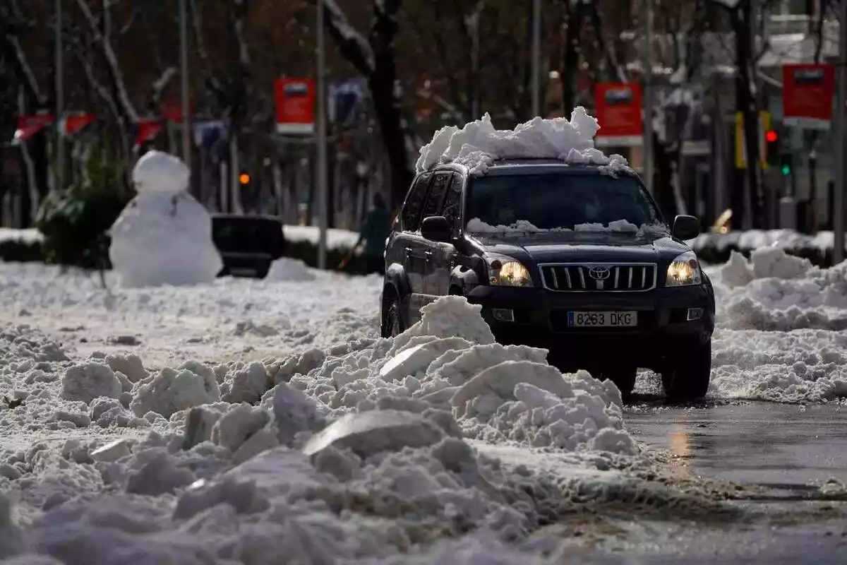 Imatge d'un cotxe pel centre de Madrid durant la nevada Filomena