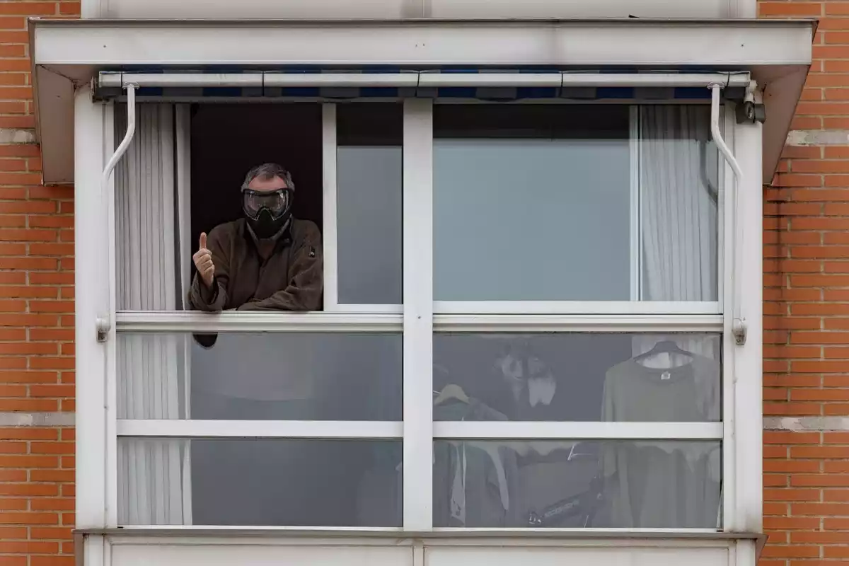 Un home saludant des de la finestra durant el confinament del 2020 a Madrid