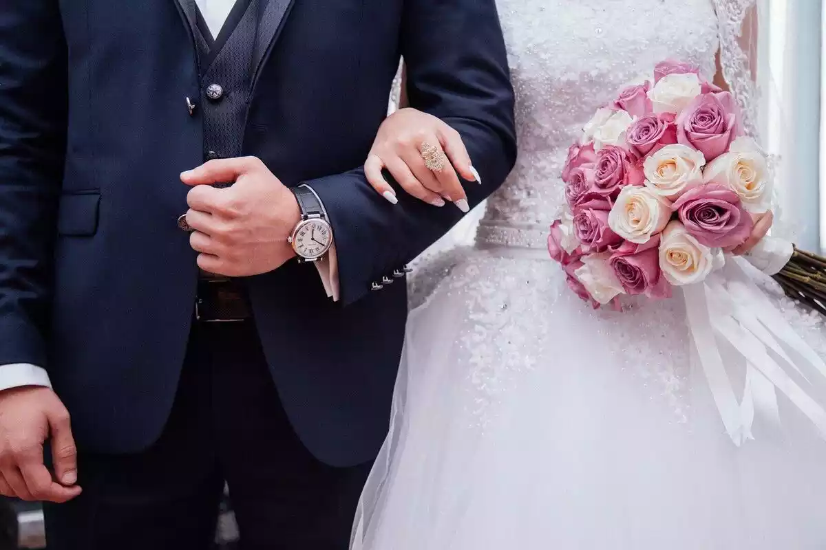 Una parella de nuvis agafant-se pels braços el dia del seu casament