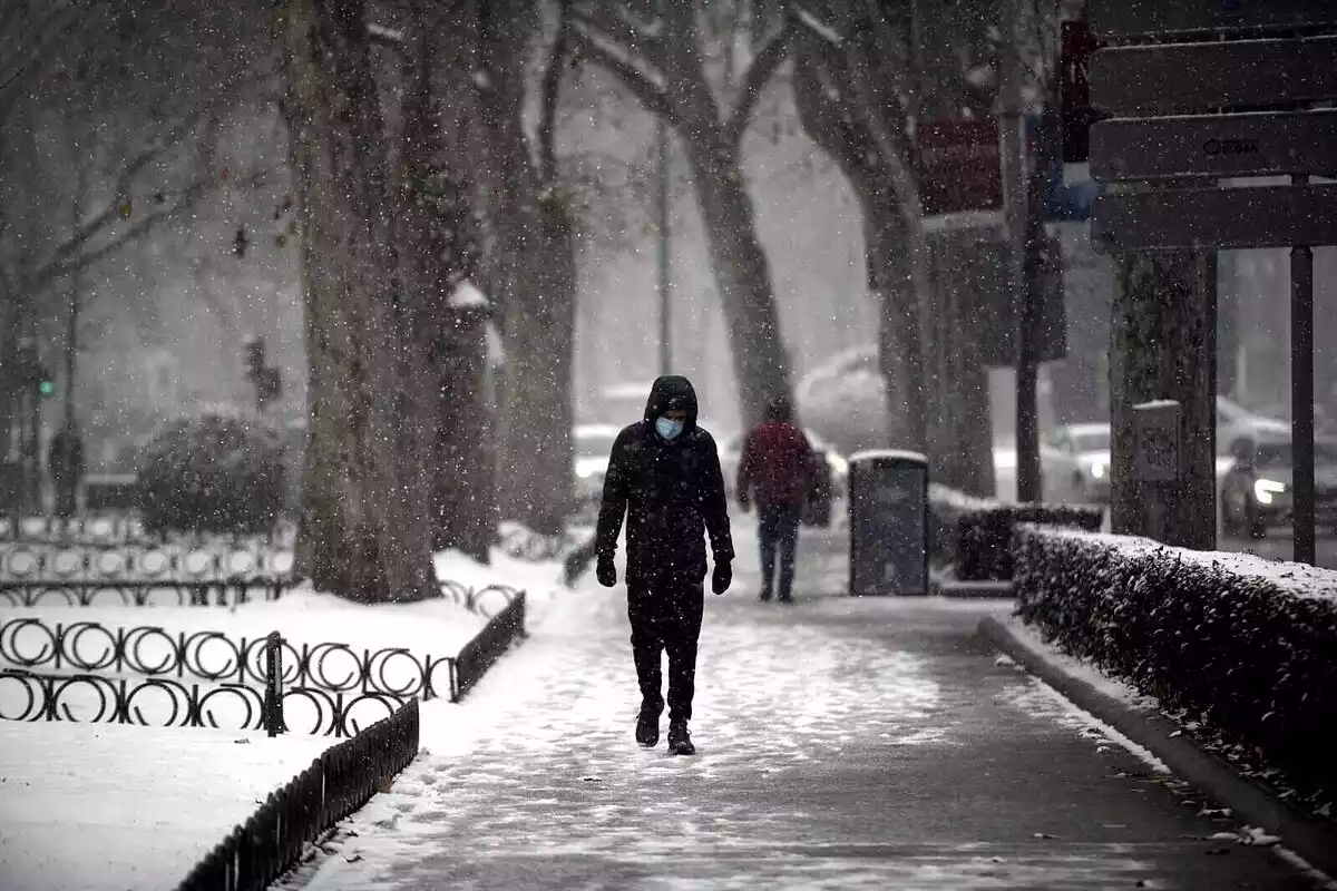 Un home que camina per la neu.