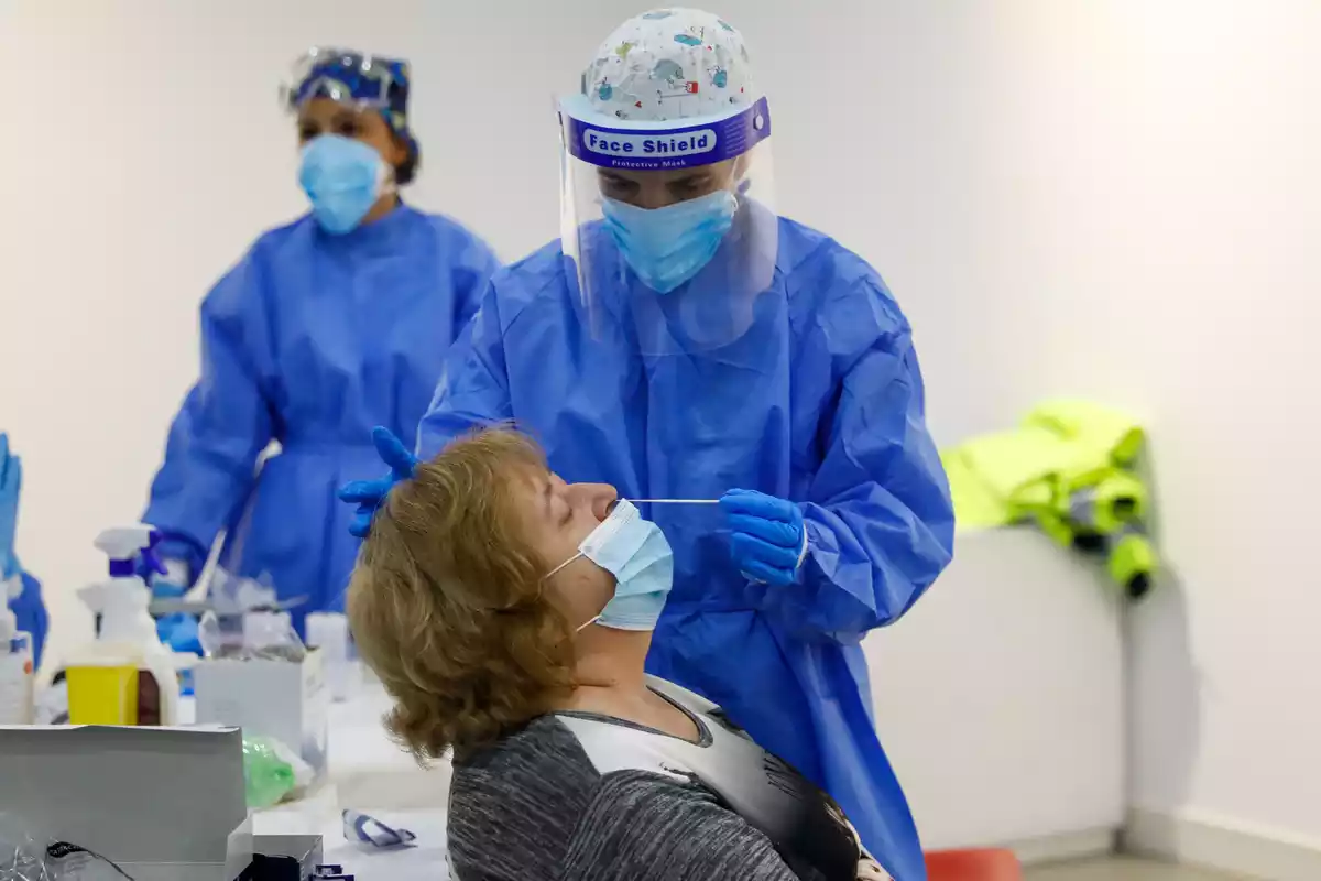 Un sanitari fent un test d'antígens a una dona