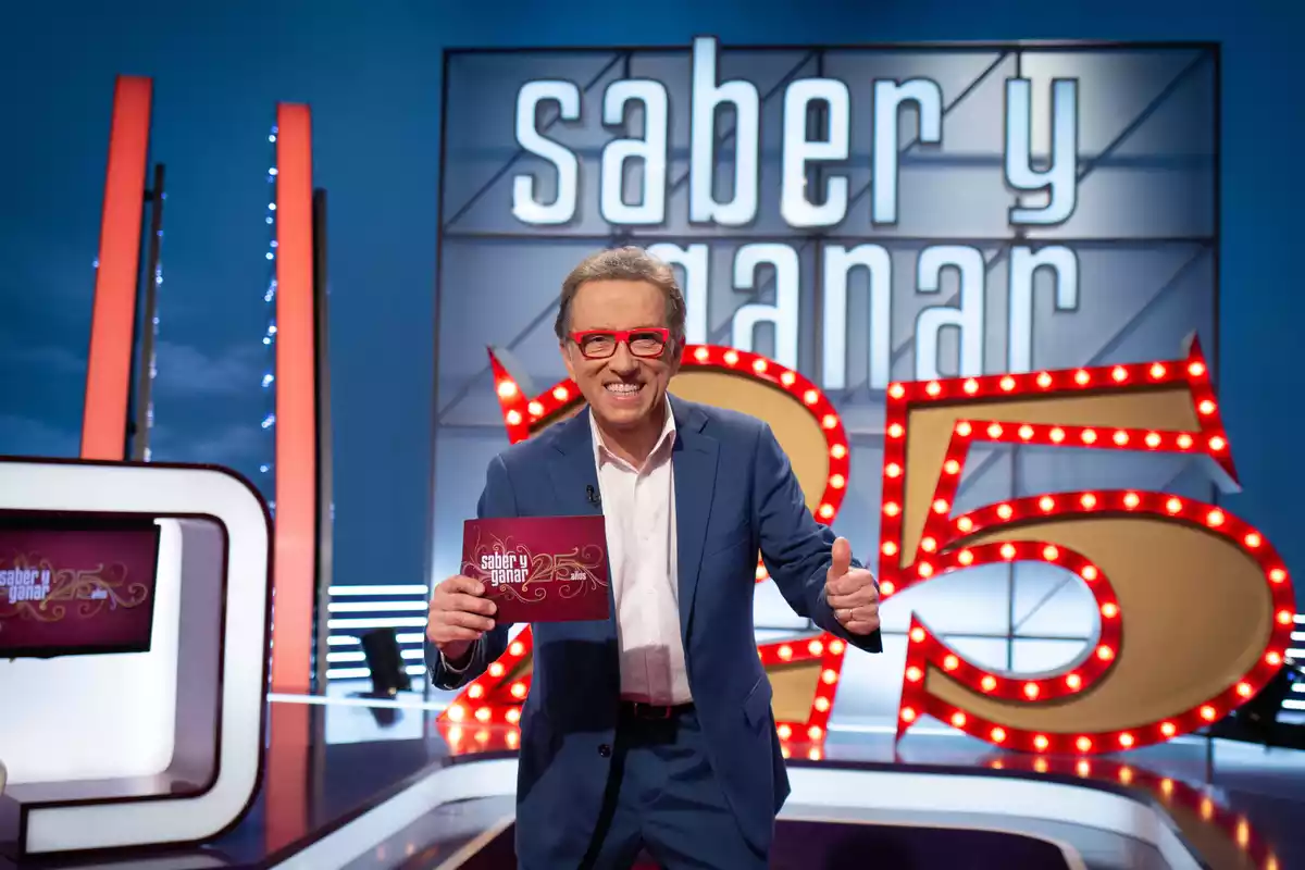 Imatge de Jordi Hurtado al plató de Saber y ganar i el logo dels 25 anys del programa