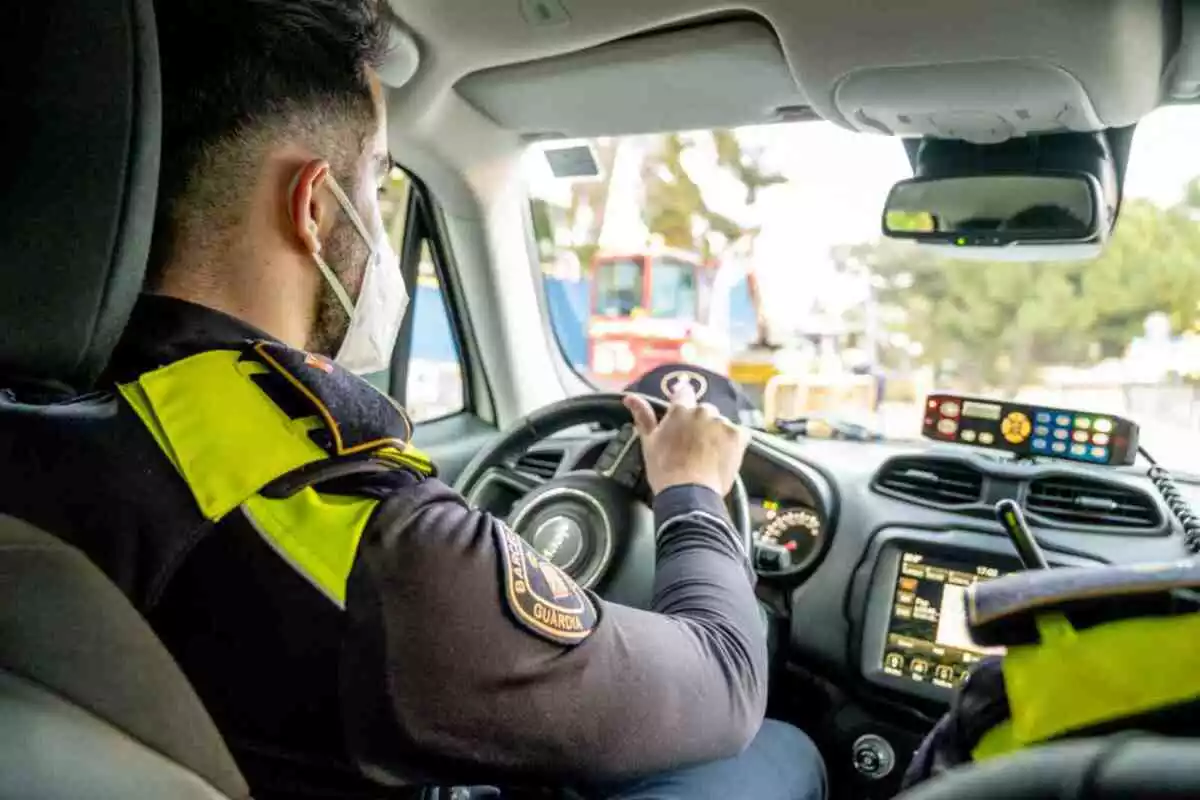 La Guàrdia Urbana de Barcelona, durant un servei en el que es pot veure un agent en un cotxe.