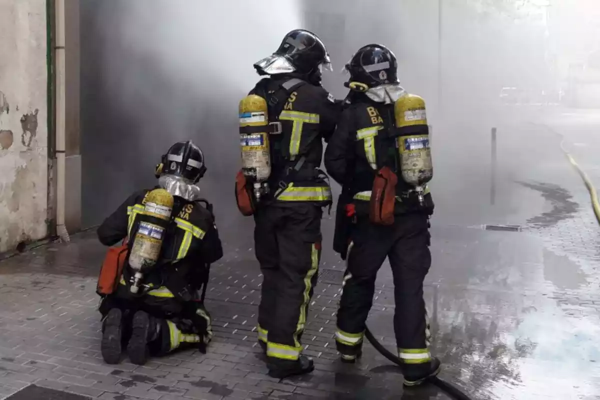 Tres membres dels Bombers de Barcelona en un incendi a la ciutat
