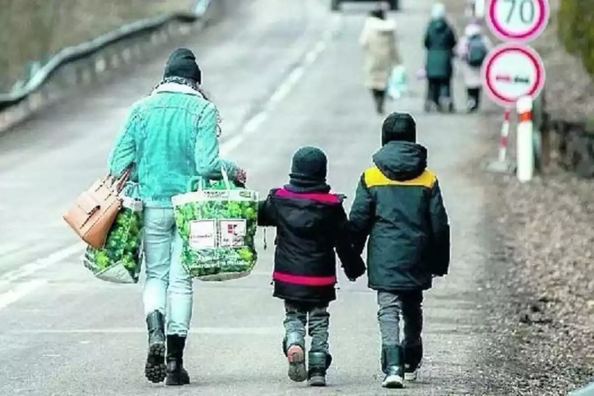 Imatge d'una mare i dos fills fugint de la guerra