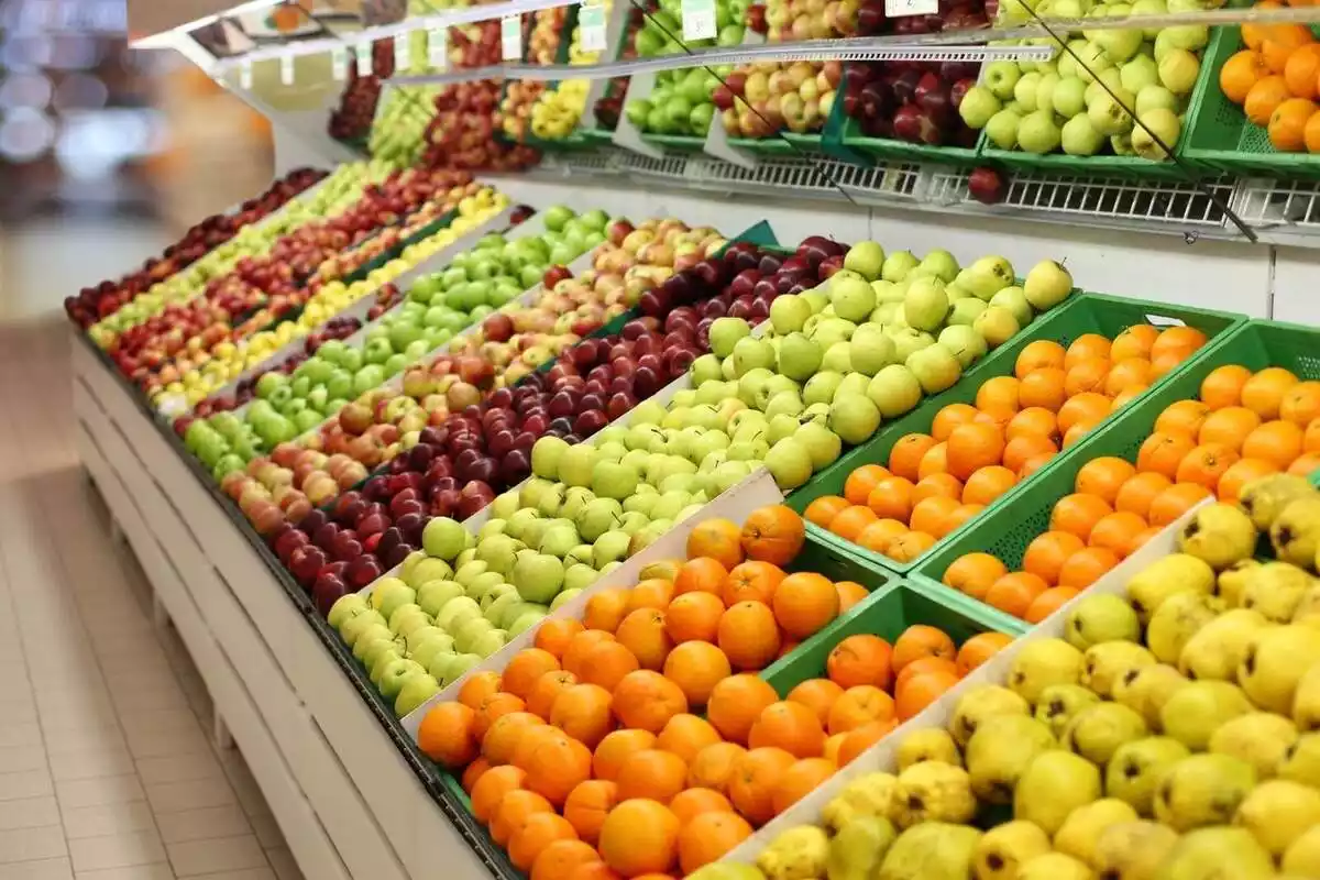 Imatge de diverses fruites com a taronges i pomes a un supermercat