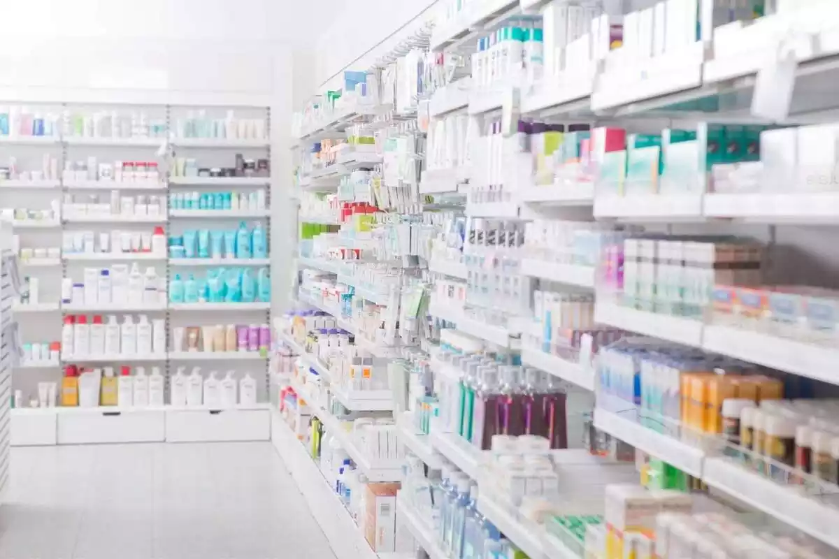 Imatge d'un passadís d'una farmàcia amb les prestatgeries plenes de productes i medicaments