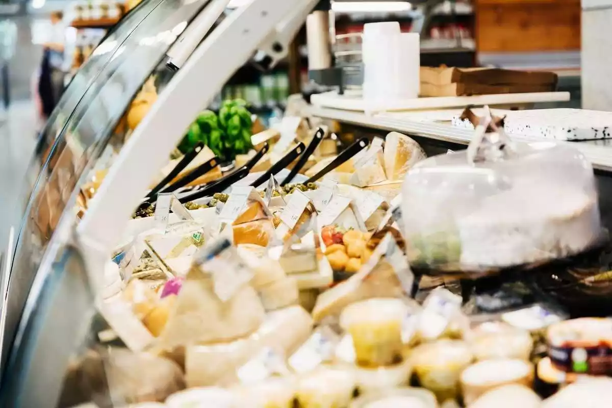 Una nevera plena de formatges en un supermercat