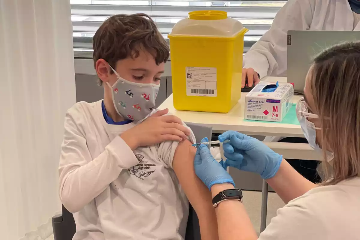 Una infermera administra a un nen la segona dosi de la vacuna contra la covid-19 en un hospital de Lleida