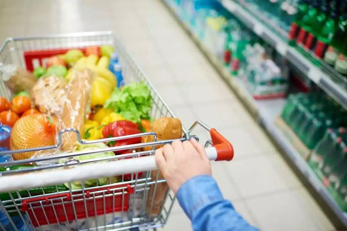 Imatge d'un carro de supermercat amb fruites i verdures.