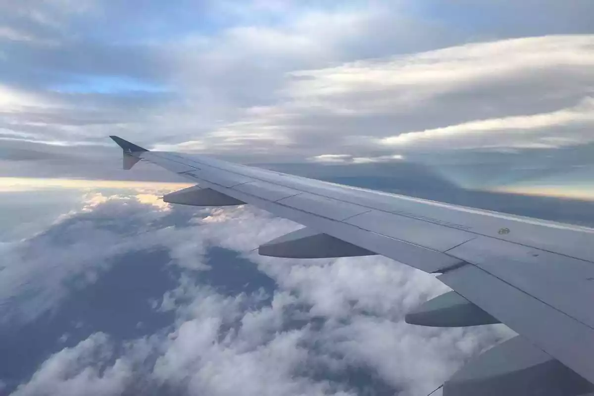 Foto de l'ala d'un avió entre els núvols.