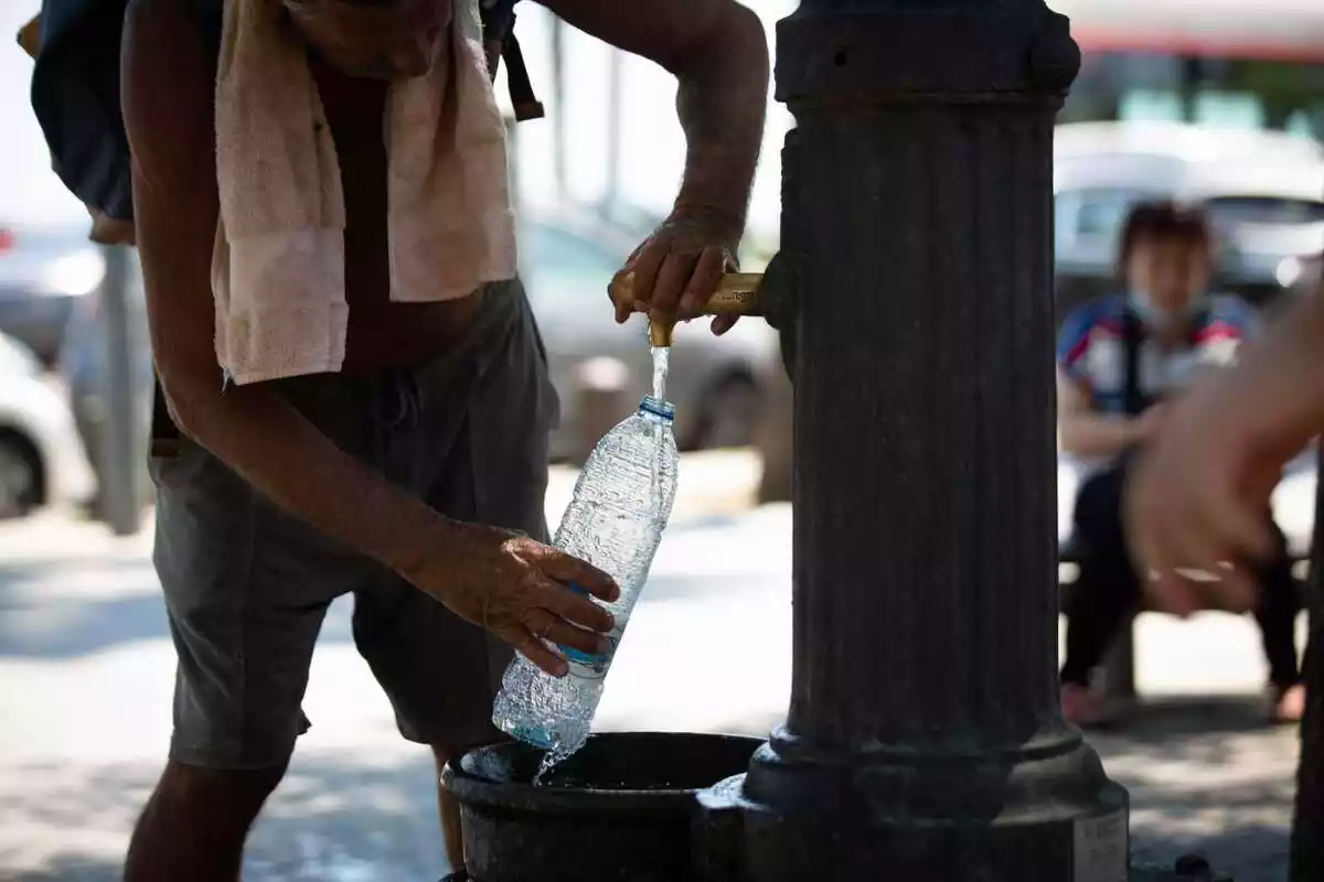 Imatge d'una persona omplint una ampolla d'aigua.