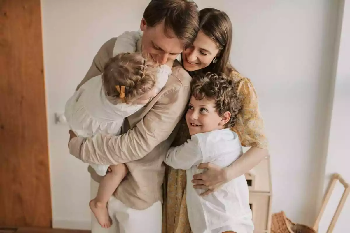 Foto d'una família fent-se una abraçada.