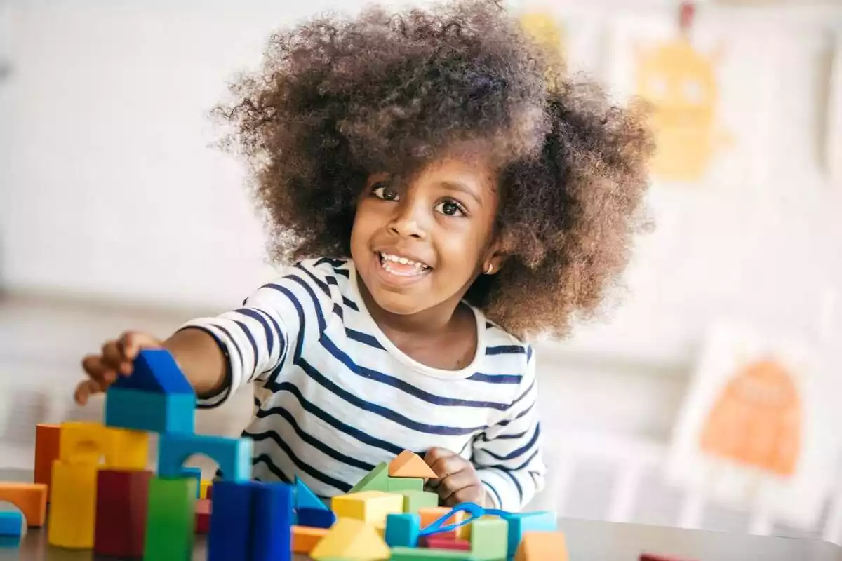 Imatge d'una nena petita jugant amb joguines de colors