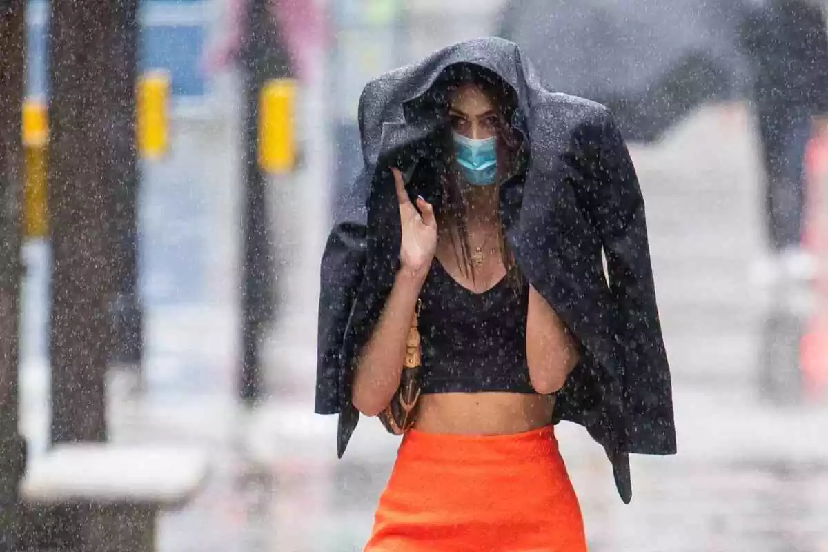 Imatge d'una noia tapant-se de la pluja a Anglaterra.