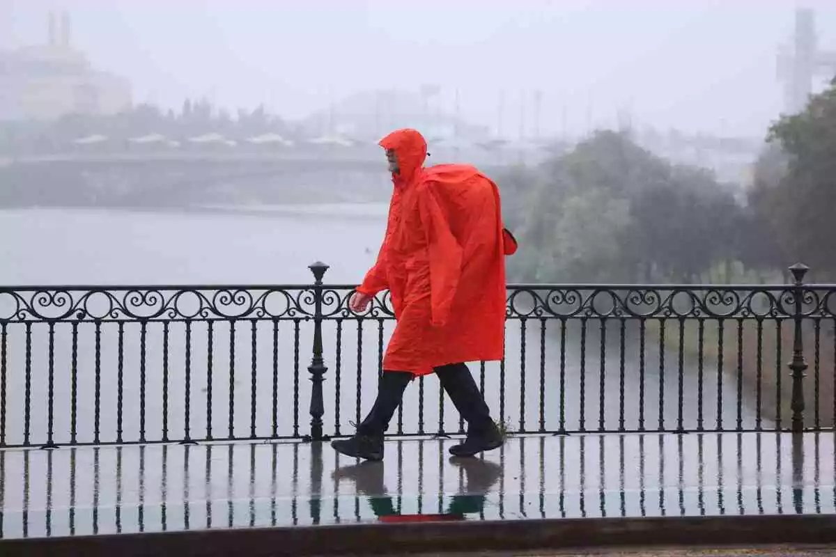 Imatge d'un home caminant sota la pluja.