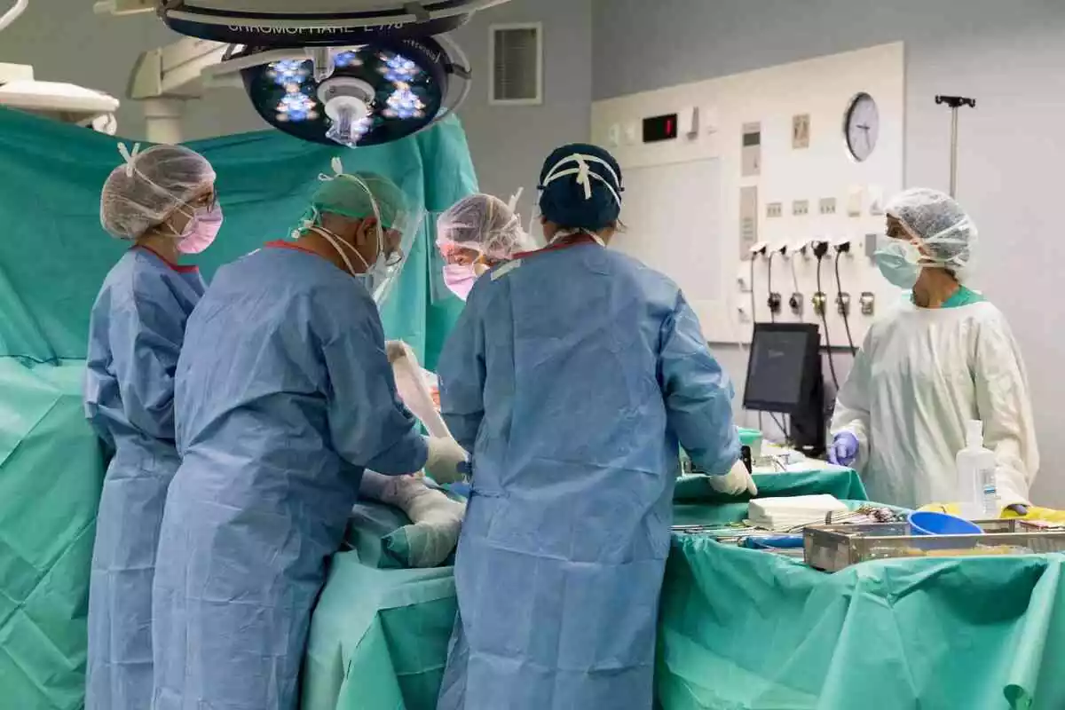 Cinc metges realitzant una operació en un hospital