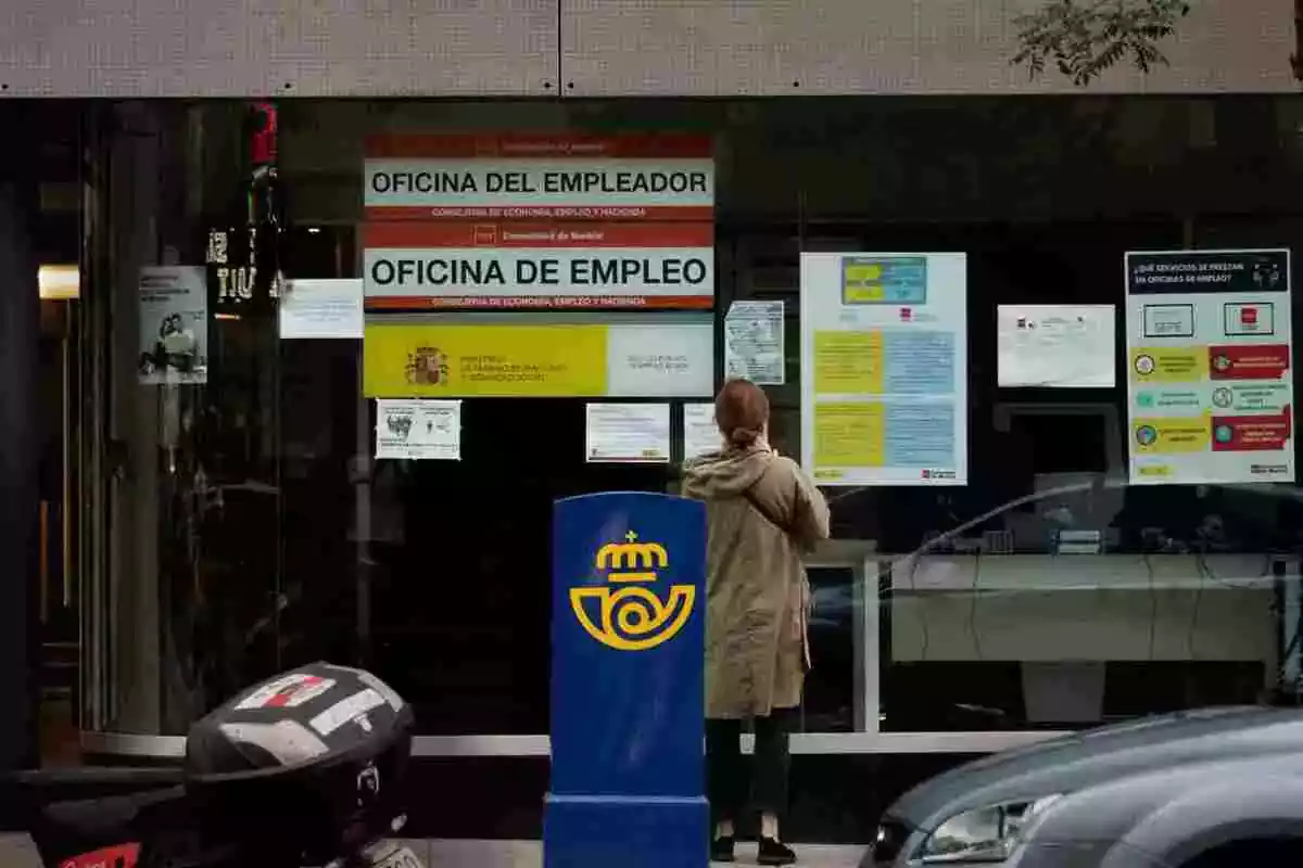 Foto d'una persona davant una oficina de treball