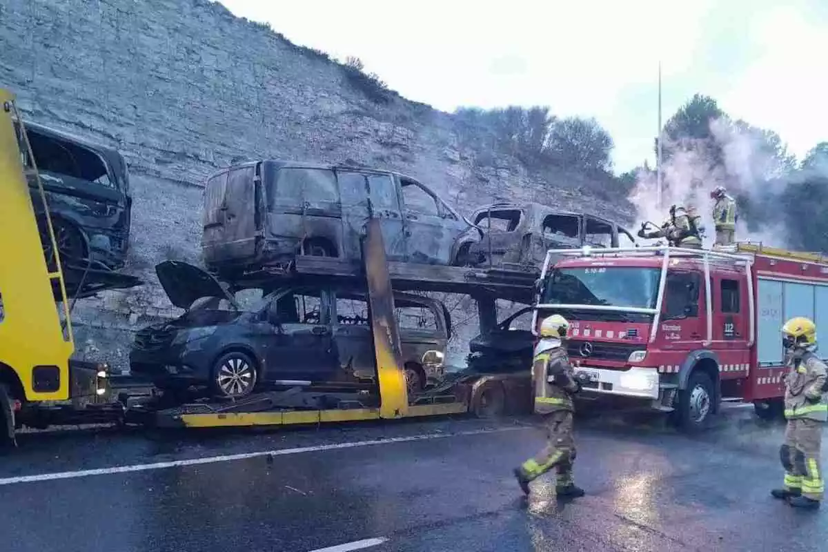 Imatge dels Bombers i un camió incendiat a l'A-2 amb totes les furgonetes que transportava cremades