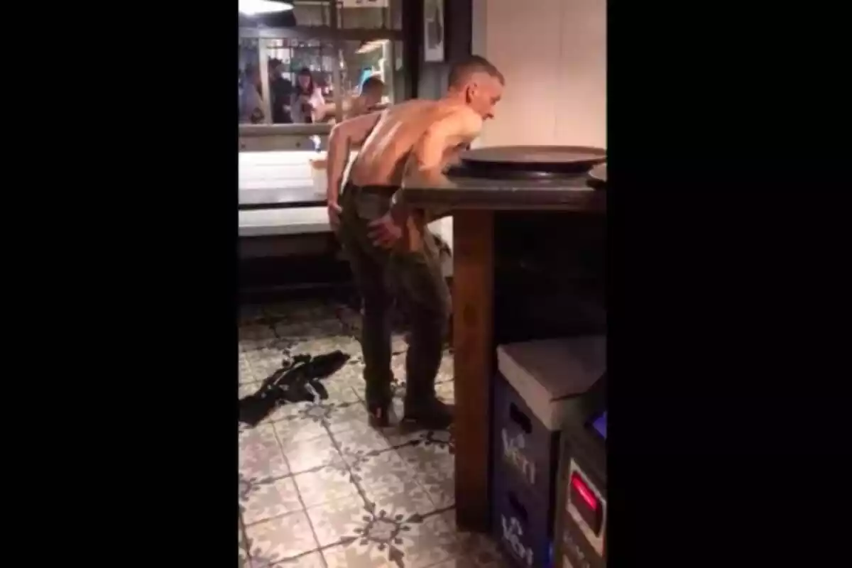 Imatge d'un home mig despullat a l'interior d'un restaurant