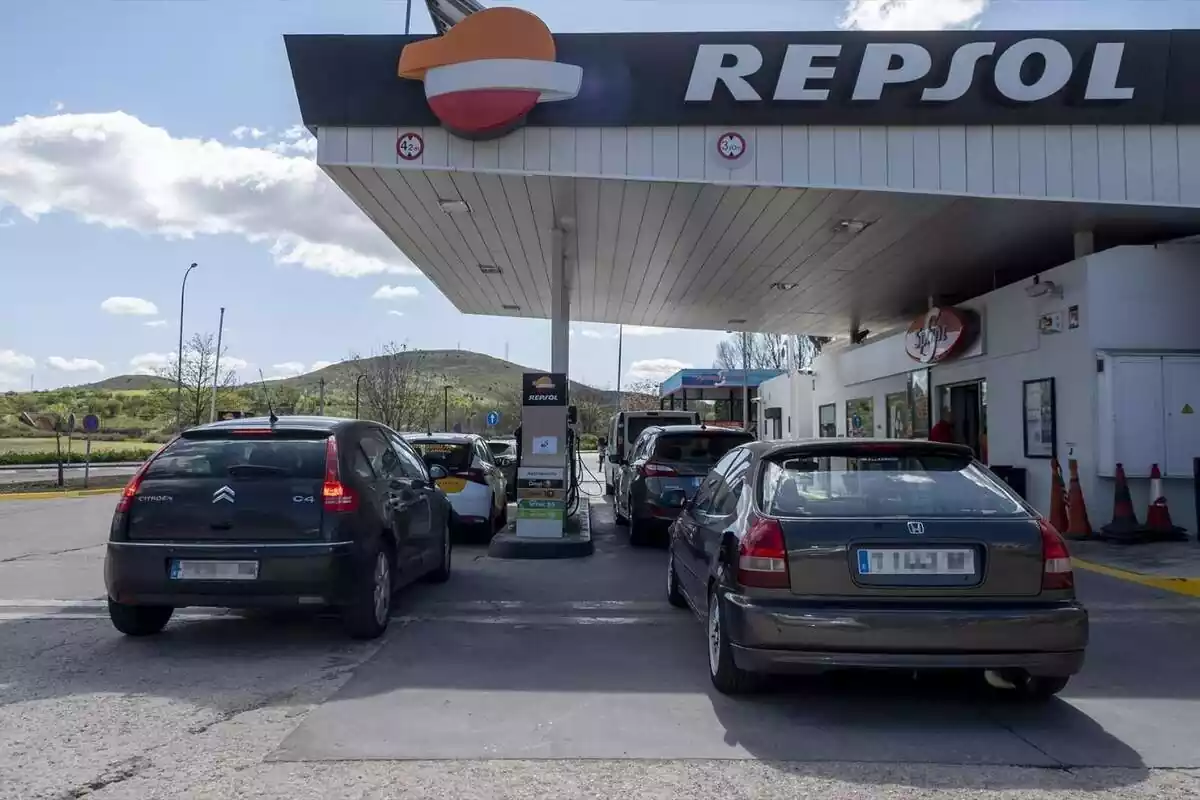 Foto de cotxes fent cua en una gasolinera Repsol.