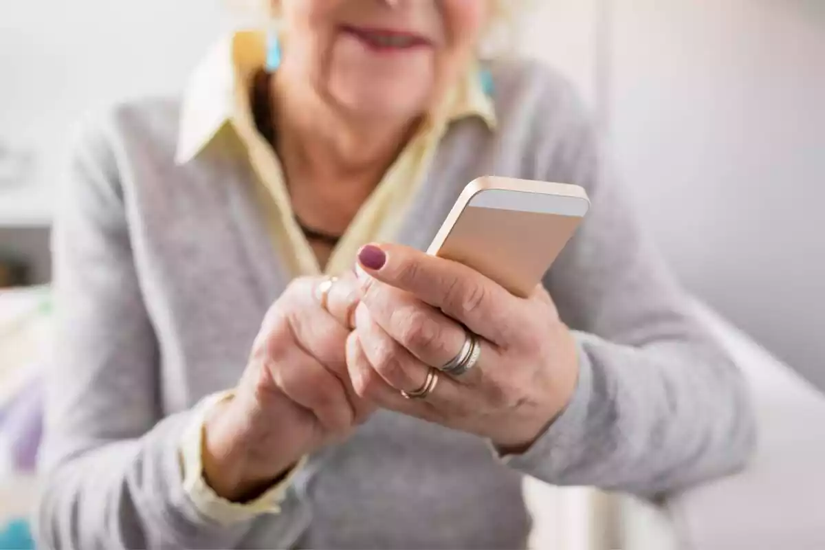 Imatge d'una dona gran amb un telèfon mòbil