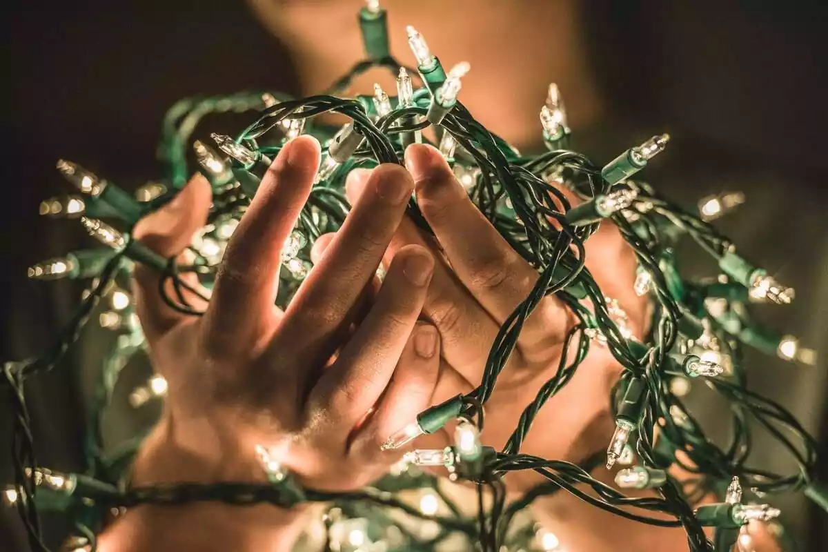 Imatge d'unes mans envoltades amb els llums de Nadal