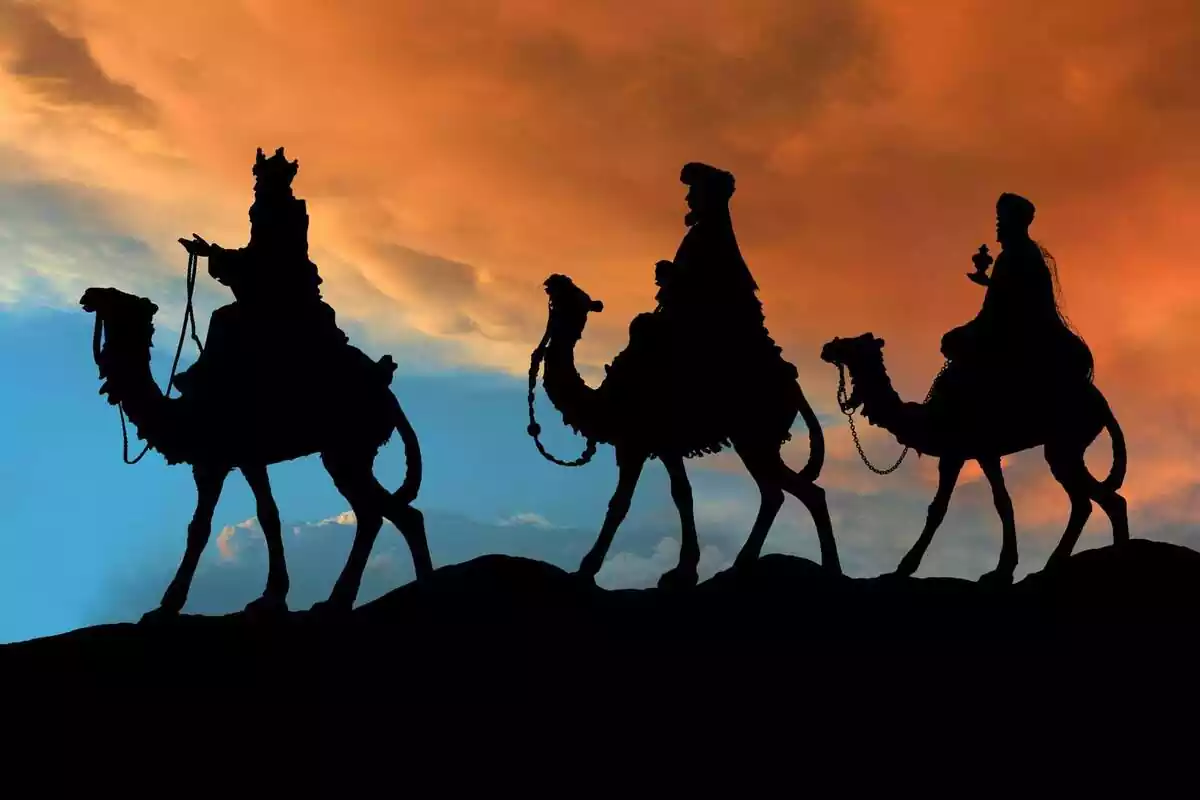 Silueta dels tres Reis Mags amb els seus camells pel desert