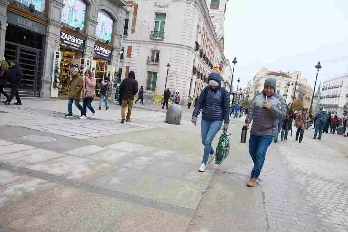 Imatge de dues persones caminant pel carrer.