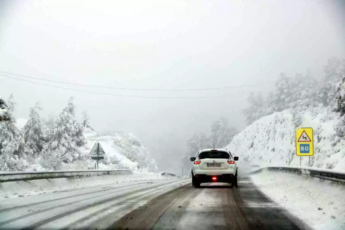 Imatge d'un cotxe per una carretera nevada