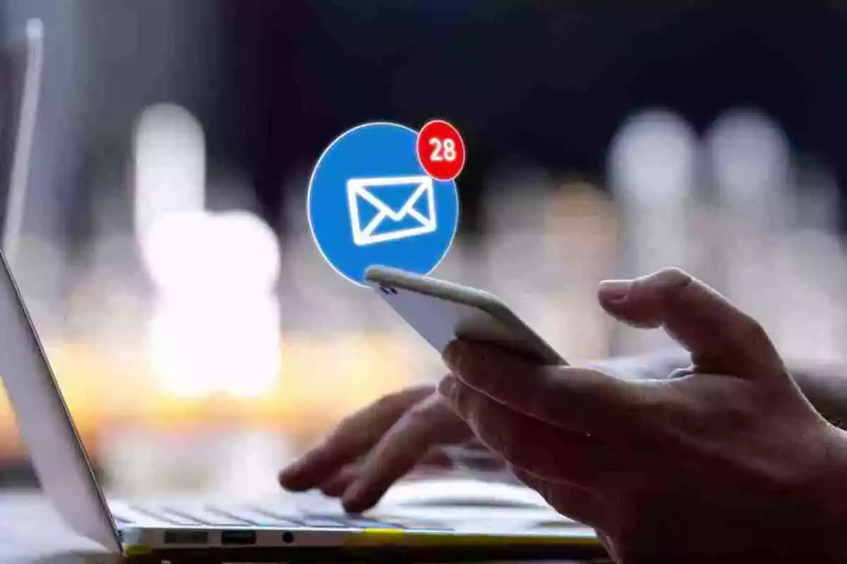 Foto d'una mà subjectant un mòbil amb una notificació de correu