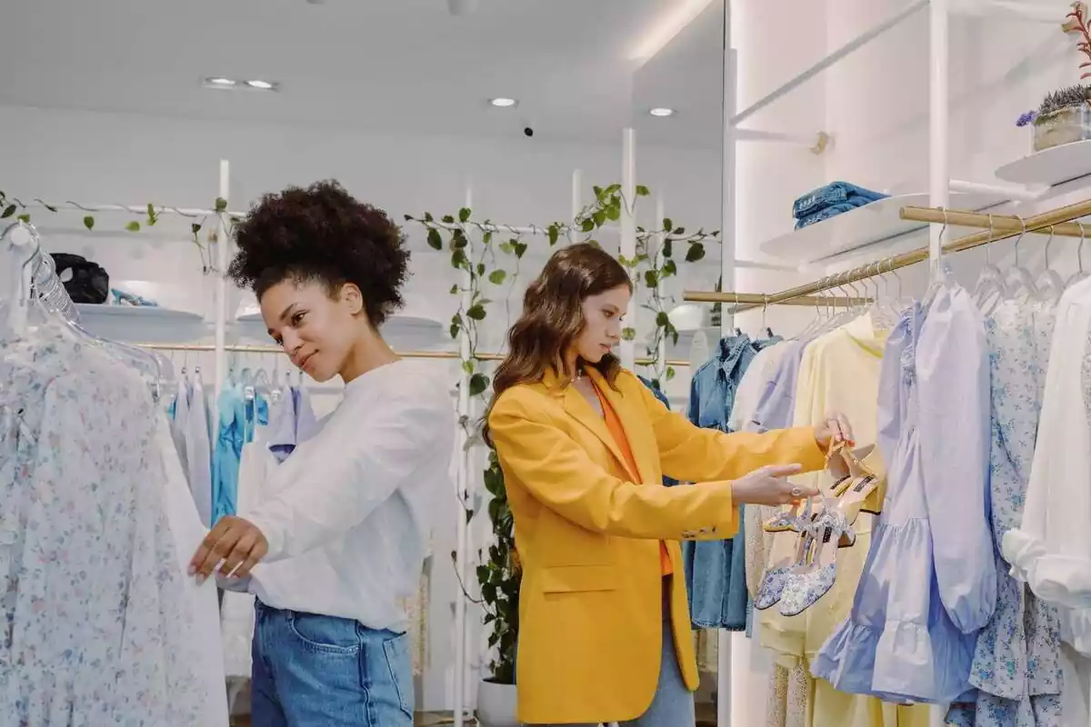 Imatge de dues dones mirant roba en una botiga