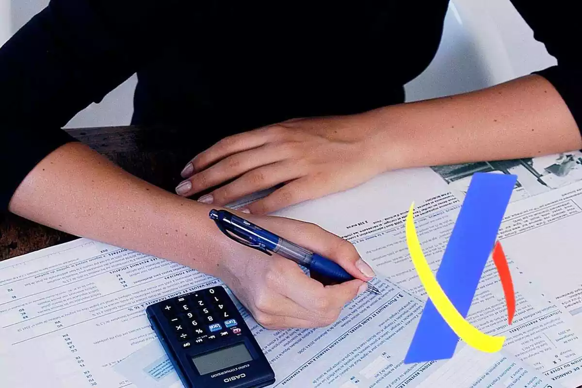 Imatge d'una dona signant papers amb una calculadora