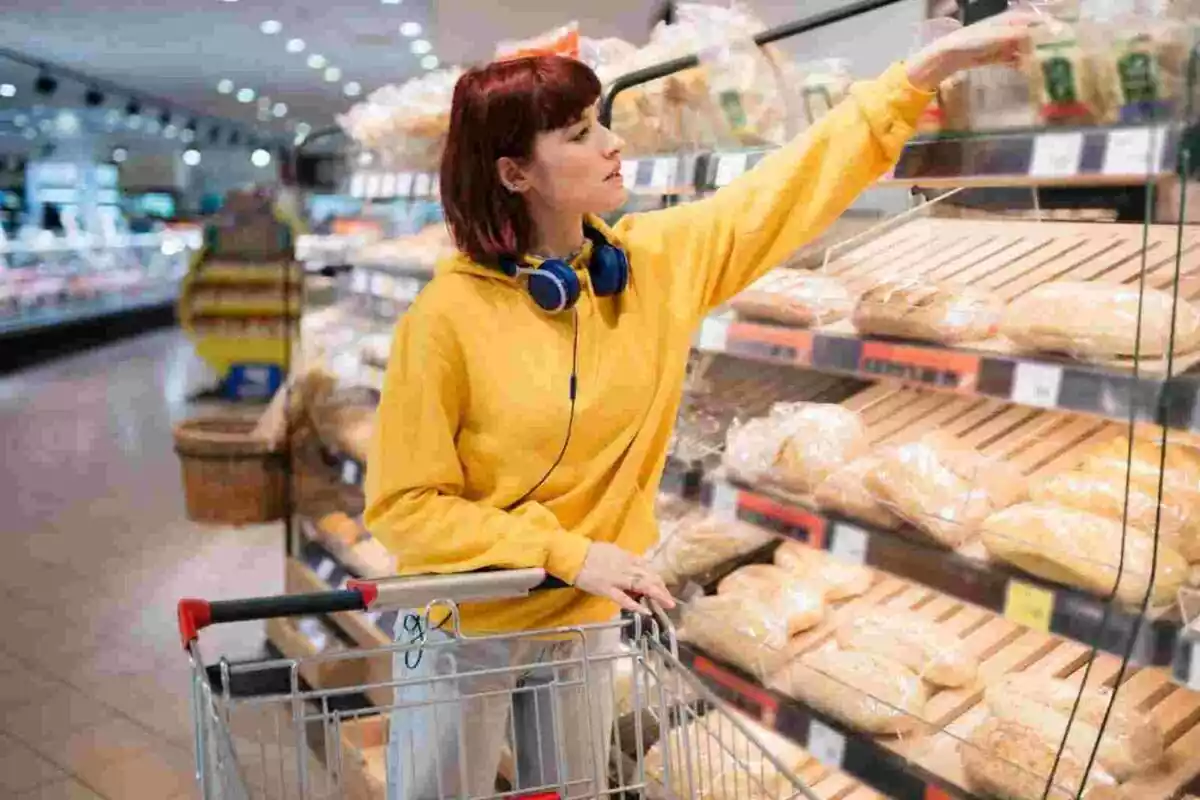 Dona comprant pa en un supermercat