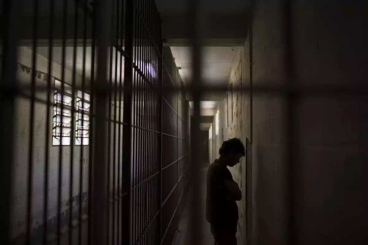 Imatge de l'interior d'una presó amb la silueta d'un pres a dins