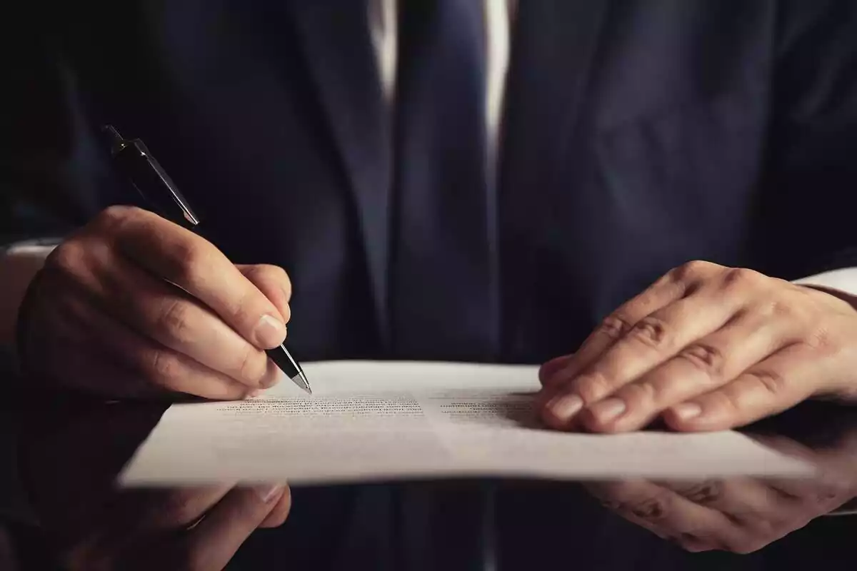 Imatge d'un home signant un document
