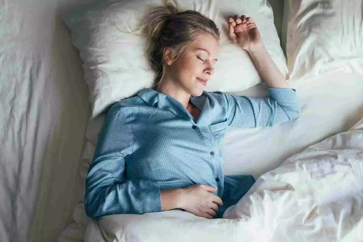 Imatge d'una noia dormint sobre el llit