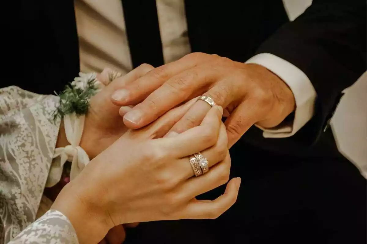 Foto d'una parella donant-se els anells en una boda.