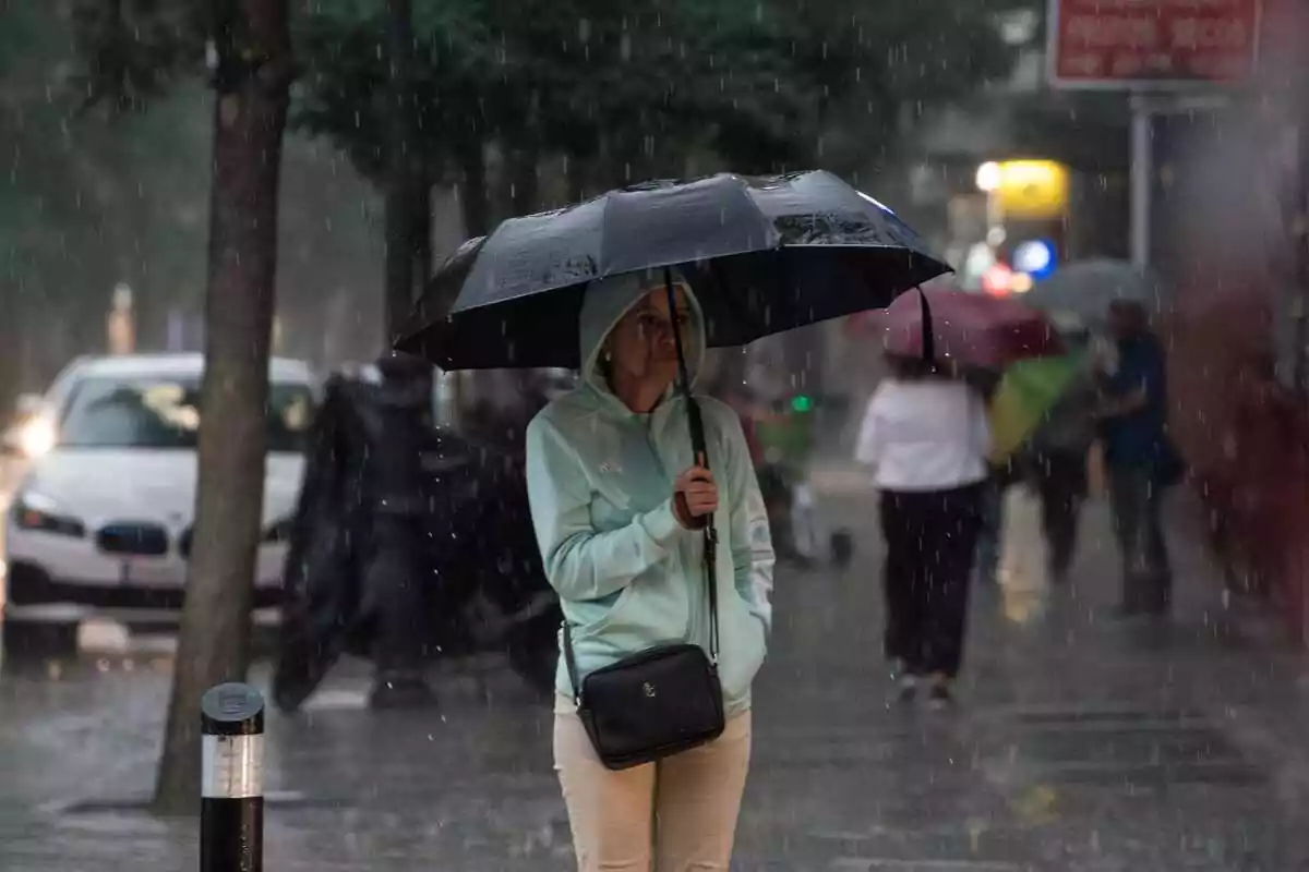 Imatge d'una dona amb un paraigues en un dia de pluges a Madrid.