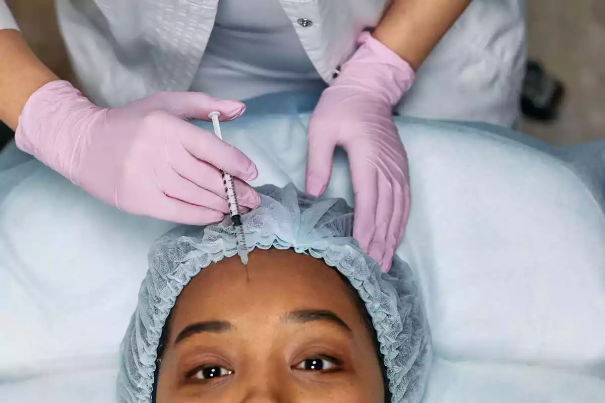 Imatge d'una dona que s'està injectant botox al front