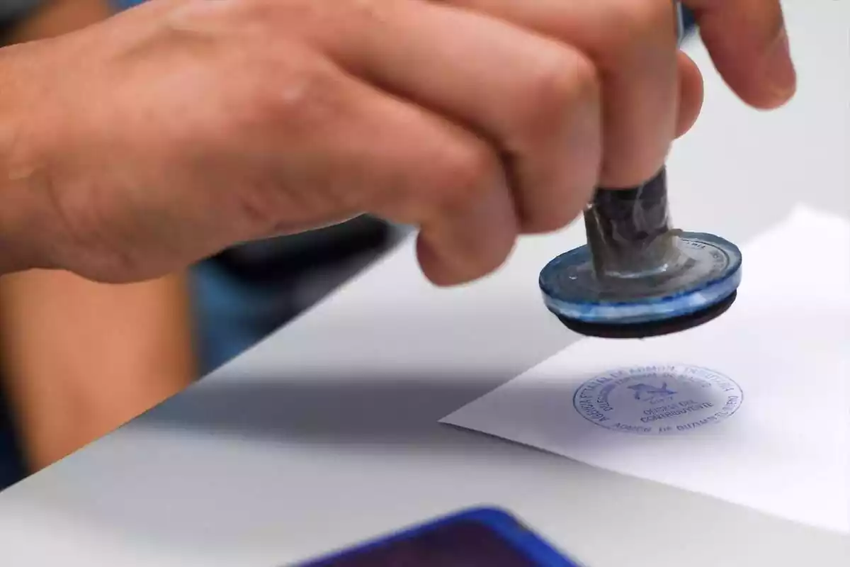 Imatge d'una persona marcant un paper amb un segell de l'Agència Tributària
