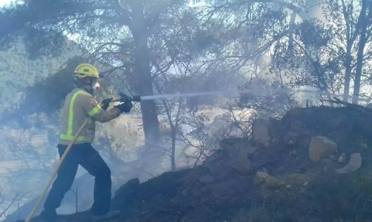 Un bomber treballant en les tasques d'extinció de l'incendi de Solivella.