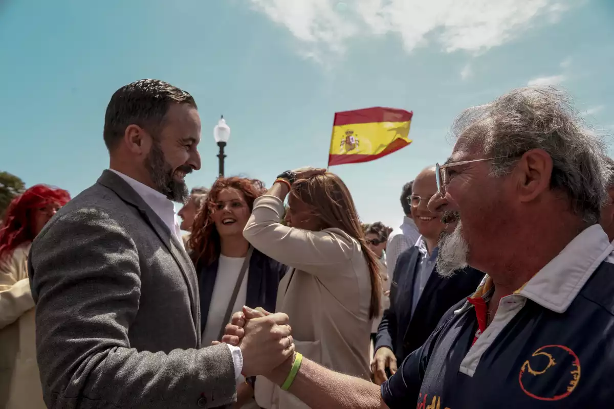 Santiago Abascal, president de VOX, saludant a un simpatitzant al balcó del Mediterrani, abans d'atendre als mitjans de comunicació a Tarragona.