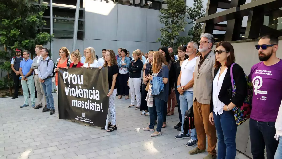 Les persones concentrades durant el minut de silenci per recordar la dona morta a mans del seu fill a Tortosa