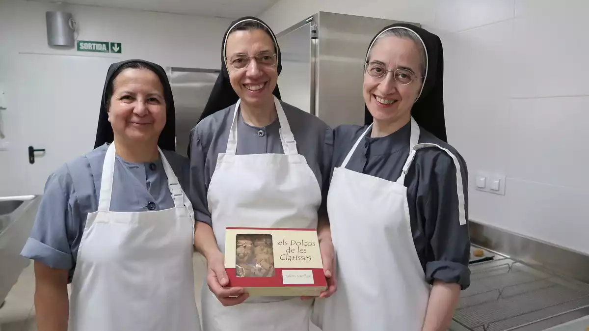 Les germanes clarisses Mercè, Teresa i Núria amb una capsa de galetes d'avellana