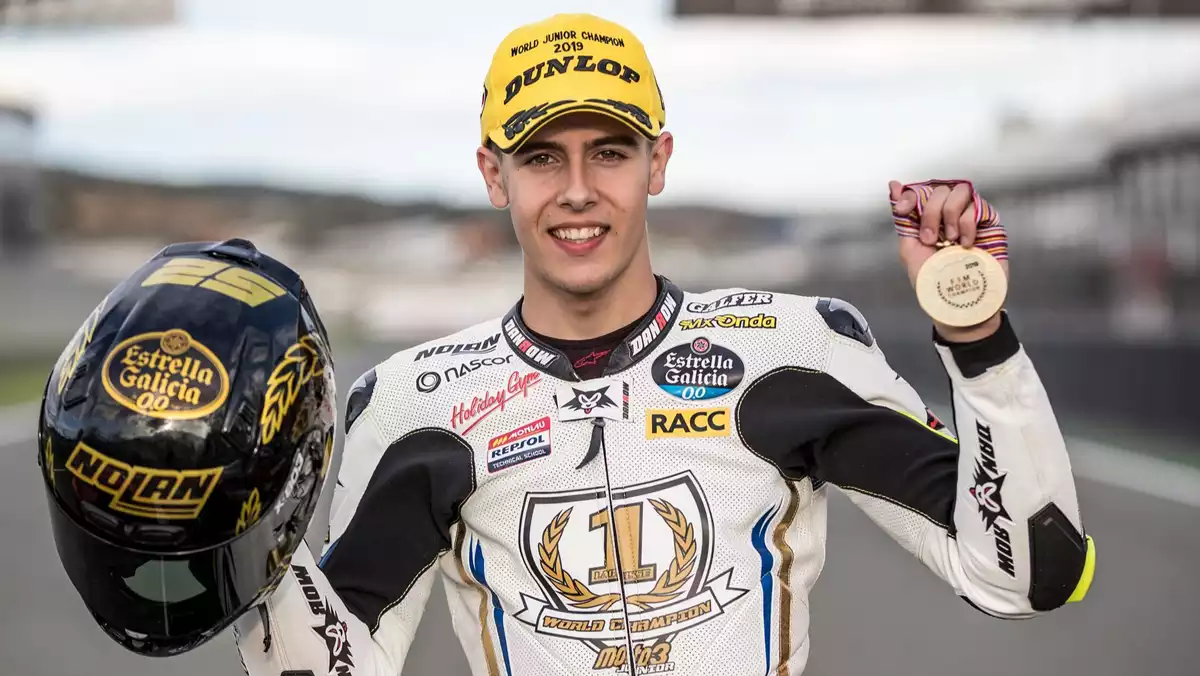 Alcoba posant com a campió del món de Moto3 Júnior